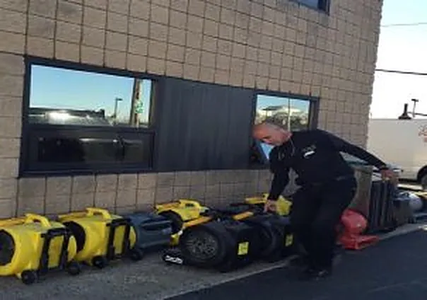 REA Floors crew staging drying equipment outside a commercial building